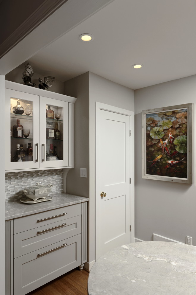 Design ideas for a large classic galley kitchen pantry in DC Metro with a submerged sink, shaker cabinets, grey cabinets, quartz worktops, grey splashback, mosaic tiled splashback, stainless steel appliances, medium hardwood flooring, a breakfast bar, brown floors and grey worktops.