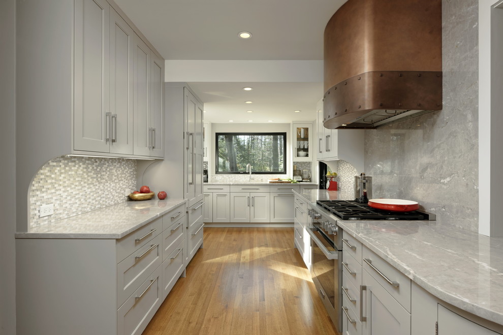 Inspiration for a large transitional galley medium tone wood floor and brown floor eat-in kitchen remodel in DC Metro with an undermount sink, shaker cabinets, gray cabinets, quartzite countertops, gray backsplash, mosaic tile backsplash, stainless steel appliances, a peninsula and gray countertops