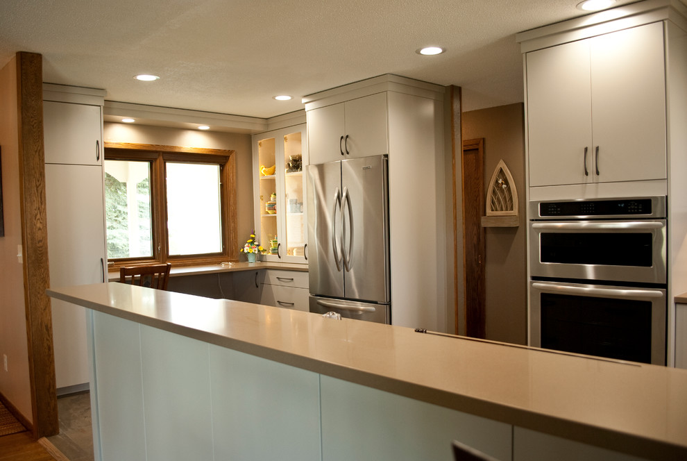 This is an example of a medium sized classic u-shaped kitchen/diner in Other with a submerged sink, flat-panel cabinets, grey cabinets, brown splashback, wood splashback, stainless steel appliances and a breakfast bar.