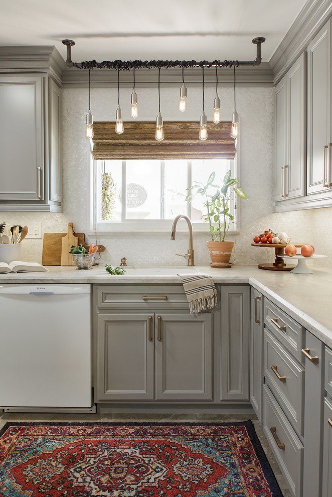 Small transitional l-shaped porcelain tile and beige floor kitchen photo in San Diego with recessed-panel cabinets, gray cabinets, quartzite countertops, white backsplash, white appliances, an island, mosaic tile backsplash, a single-bowl sink and white countertops