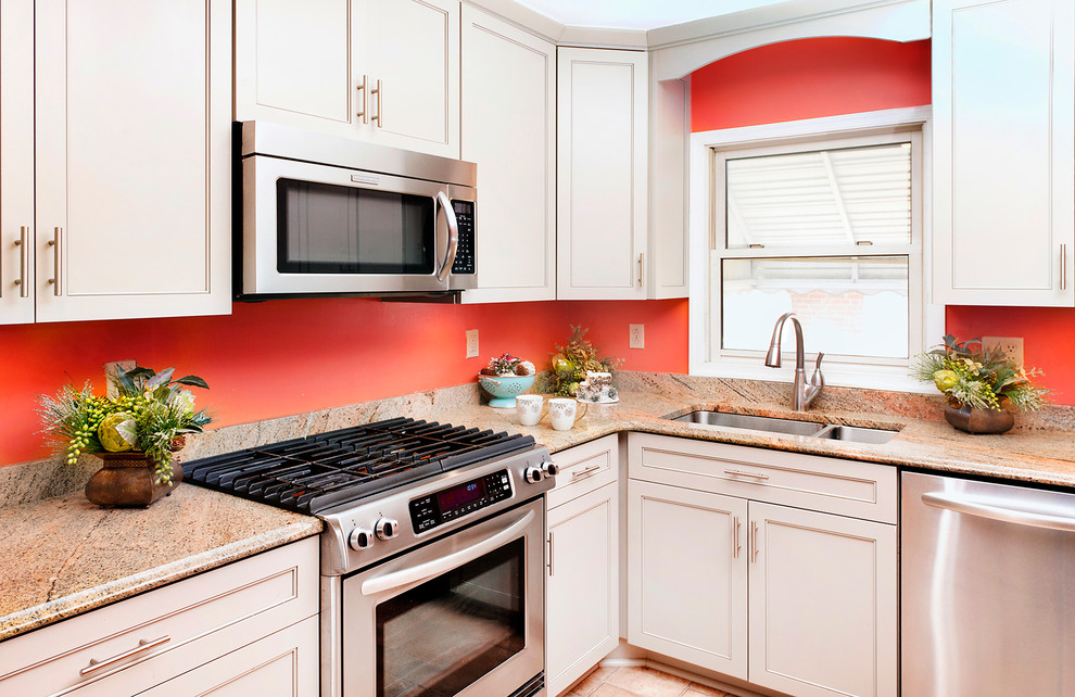 Inredning av ett klassiskt avskilt, litet brun brunt l-kök, med en undermonterad diskho, luckor med infälld panel, vita skåp, granitbänkskiva, rostfria vitvaror, klinkergolv i keramik och orange golv