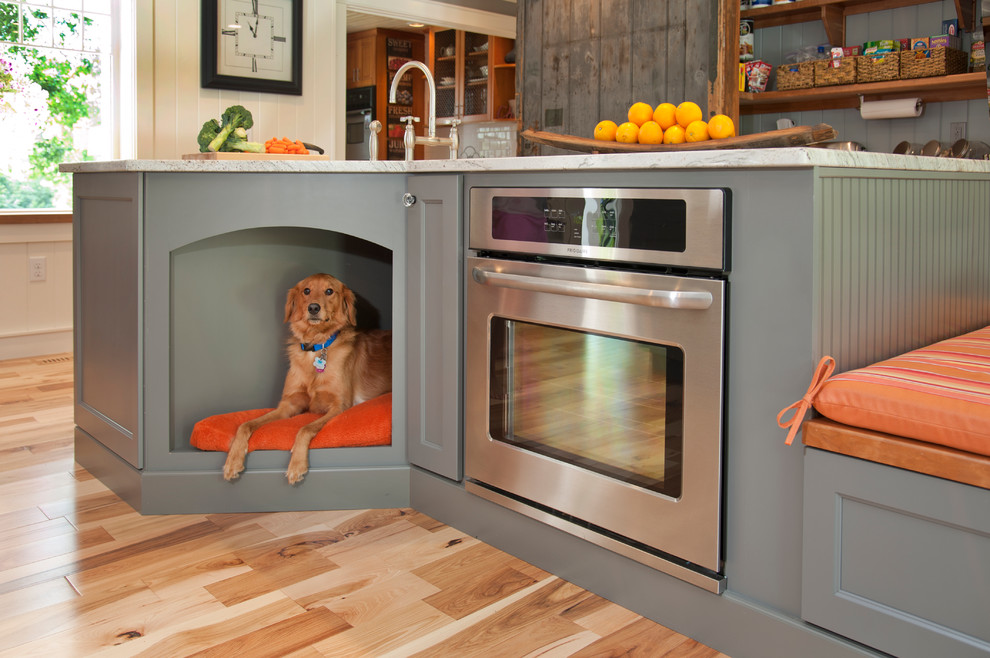 Large eclectic u-shaped light wood floor open concept kitchen photo in Manchester with a farmhouse sink, flat-panel cabinets, gray cabinets, granite countertops, stainless steel appliances and an island