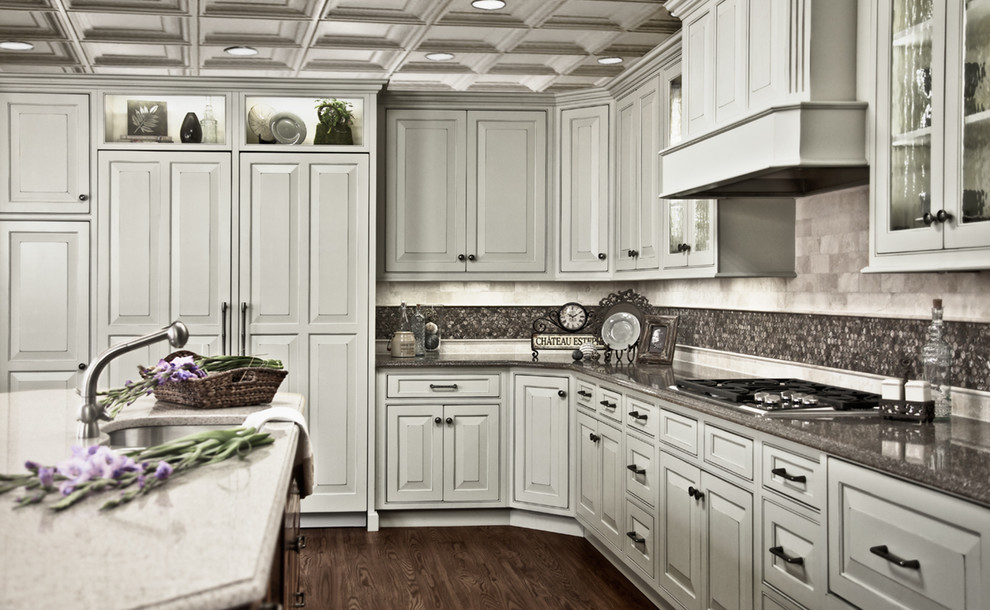 Klassische Wohnküche mit grauen Schränken, Granit-Arbeitsplatte, Küchenrückwand in Grau, Rückwand aus Metallfliesen und Elektrogeräten mit Frontblende in Portland
