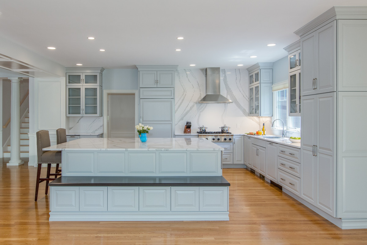 Open concept kitchen - large transitional l-shaped medium tone wood floor open concept kitchen idea in Boston with an undermount sink, raised-panel cabinets, gray cabinets, quartz countertops, stone slab backsplash, paneled appliances and an island