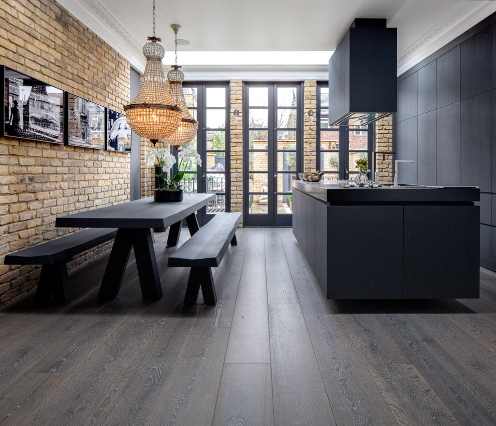 Exempel på ett mellanstort eklektiskt kök och matrum, med släta luckor, svarta skåp, mörkt trägolv, en köksö, brunt golv och integrerade vitvaror