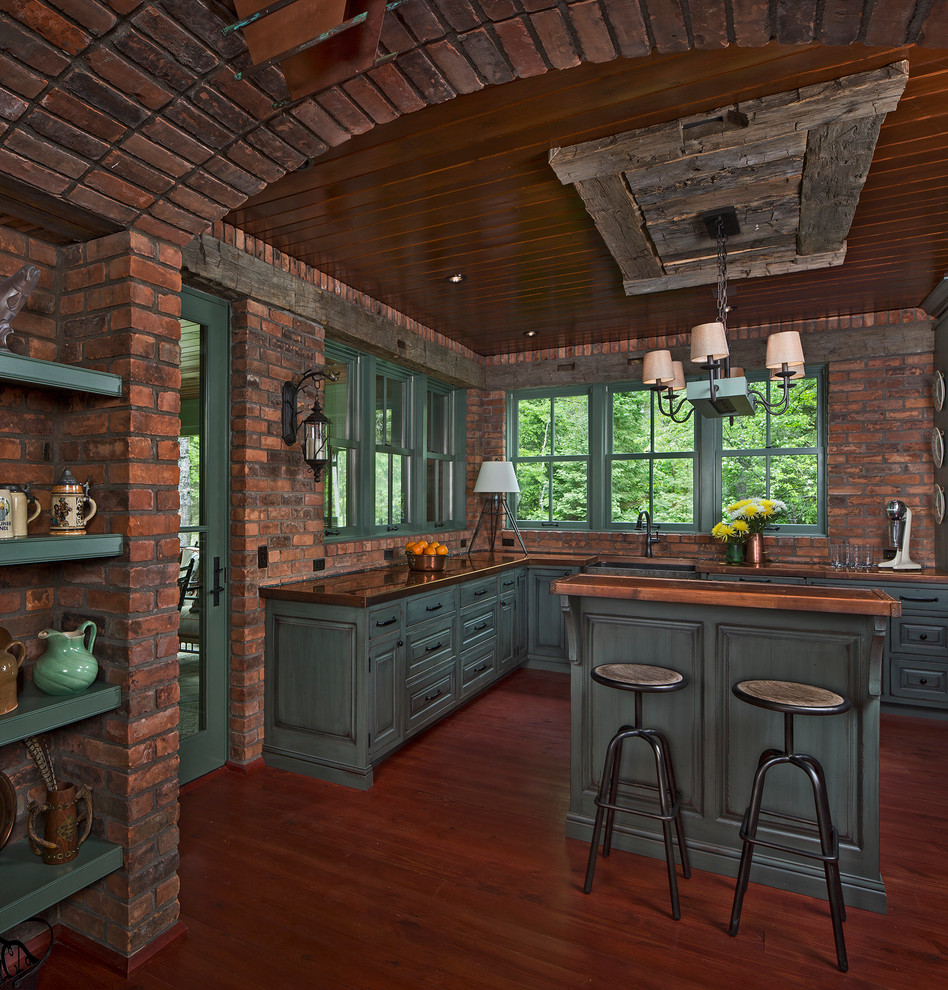 Rustikale Küche in U-Form mit Landhausspüle, grünen Schränken, Kupfer-Arbeitsplatte, braunem Holzboden und Kücheninsel in Detroit