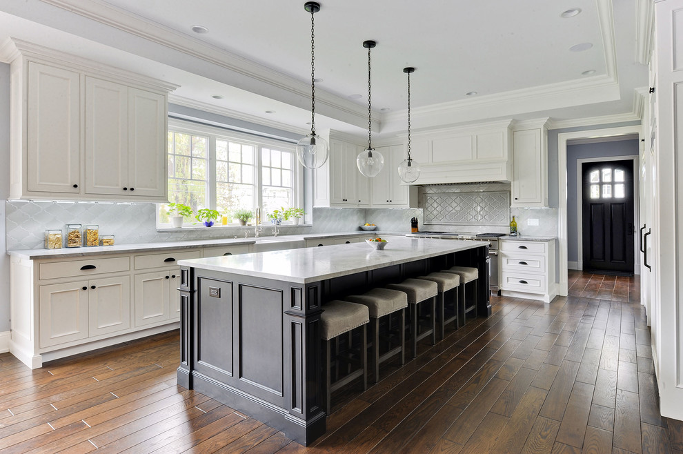 Inspiration for a classic l-shaped kitchen in Chicago with a belfast sink, recessed-panel cabinets, grey splashback, medium hardwood flooring and an island.