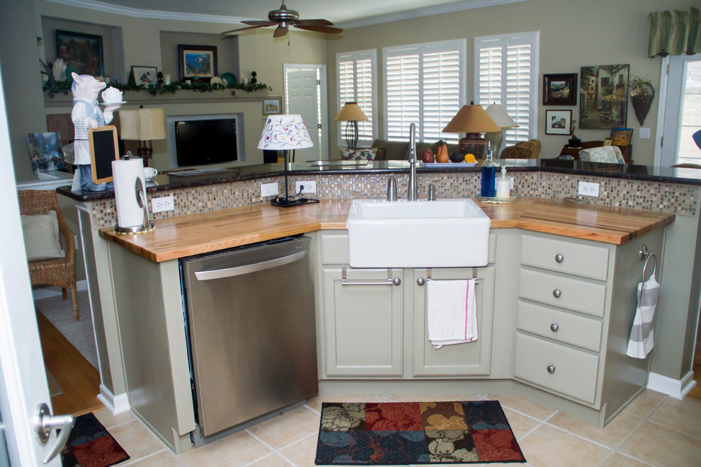Example of a large farmhouse galley ceramic tile eat-in kitchen design in Denver with a farmhouse sink, flat-panel cabinets, green cabinets, wood countertops, multicolored backsplash, glass sheet backsplash, stainless steel appliances and an island