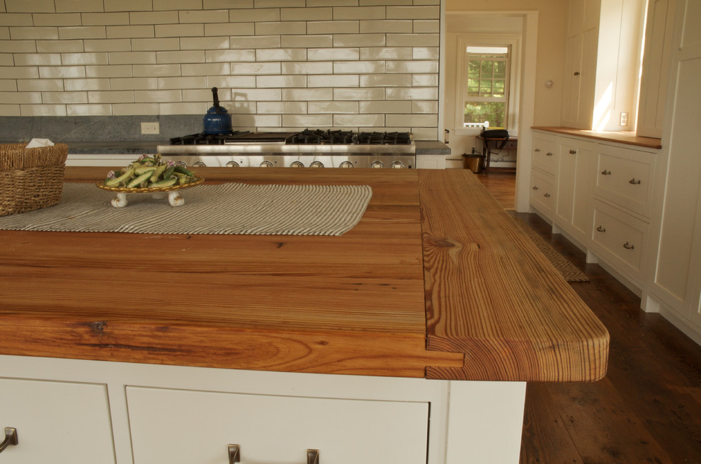Inspiration for a mid-sized farmhouse l-shaped dark wood floor eat-in kitchen remodel in Boston with a farmhouse sink, shaker cabinets, white cabinets, soapstone countertops, blue backsplash, stone slab backsplash, stainless steel appliances and an island