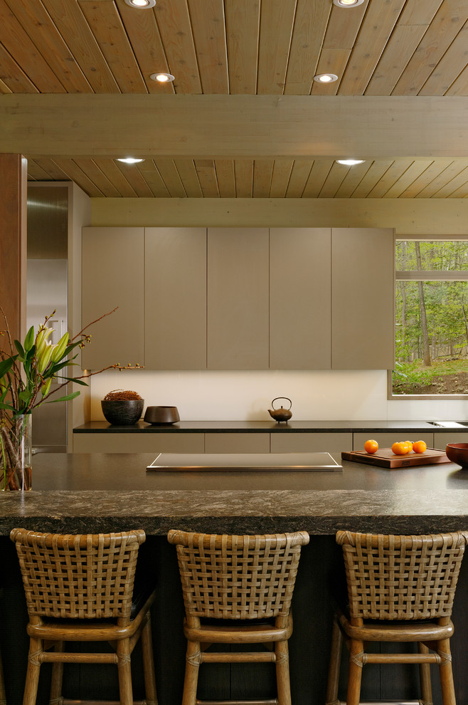 Foto di una cucina contemporanea di medie dimensioni con ante lisce, lavello sottopiano, ante in legno bruno, elettrodomestici in acciaio inossidabile, parquet scuro, top in superficie solida e paraspruzzi bianco