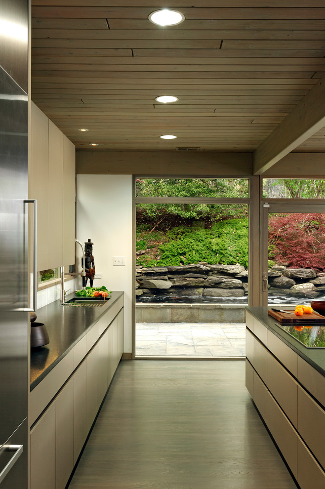 Modern inredning av ett mellanstort kök, med släta luckor, en undermonterad diskho, rostfria vitvaror, mörkt trägolv, en köksö, skåp i mörkt trä, bänkskiva i koppar och vitt stänkskydd