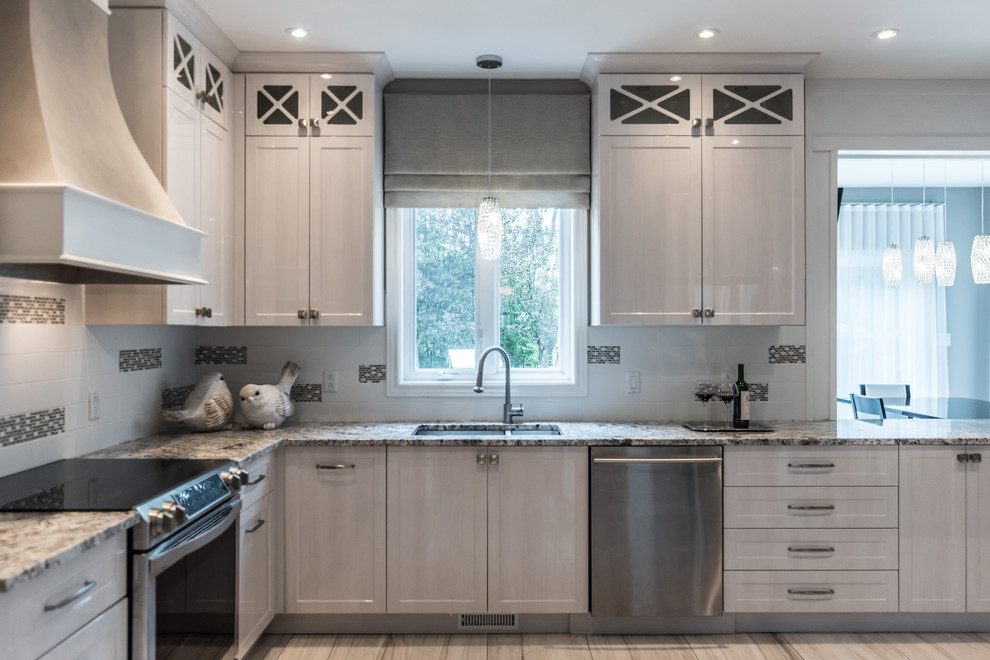 Photo of a medium sized classic u-shaped kitchen/diner in Montreal with a submerged sink, shaker cabinets, white cabinets, granite worktops, yellow splashback, ceramic splashback, stainless steel appliances, porcelain flooring, a breakfast bar, grey floors and multicoloured worktops.
