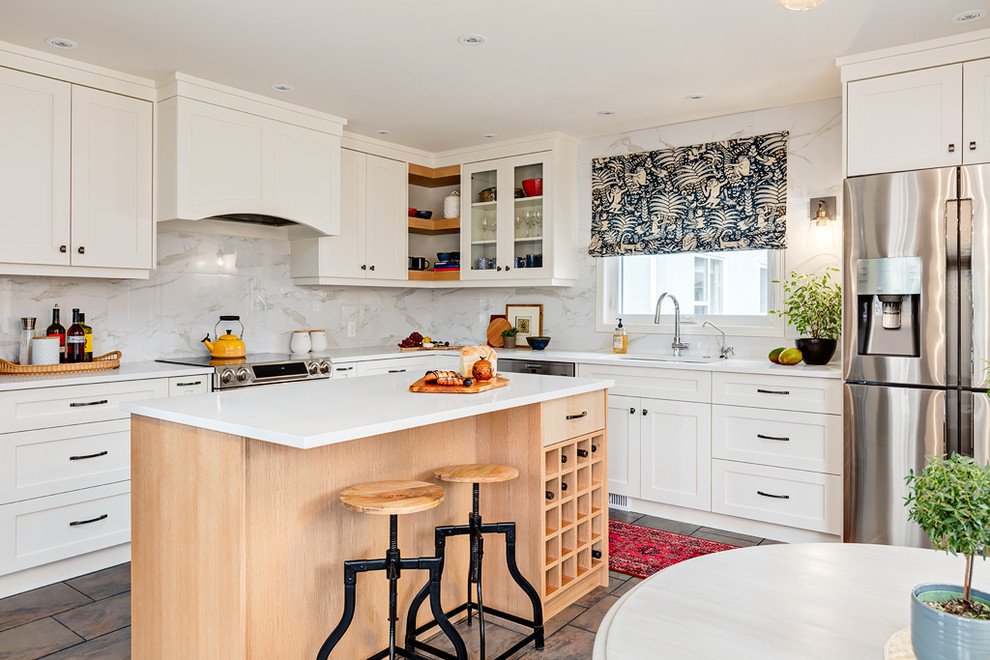 Kitchen - mid-sized transitional l-shaped ceramic tile and brown floor kitchen idea in Calgary with an undermount sink, shaker cabinets, white cabinets, quartz countertops, white backsplash, porcelain backsplash, stainless steel appliances and an island