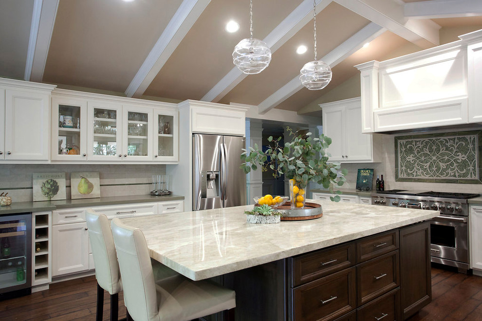 Example of a large transitional u-shaped dark wood floor and brown floor open concept kitchen design in San Francisco with recessed-panel cabinets, white cabinets, quartzite countertops, beige backsplash, an island, stone tile backsplash, stainless steel appliances and a double-bowl sink