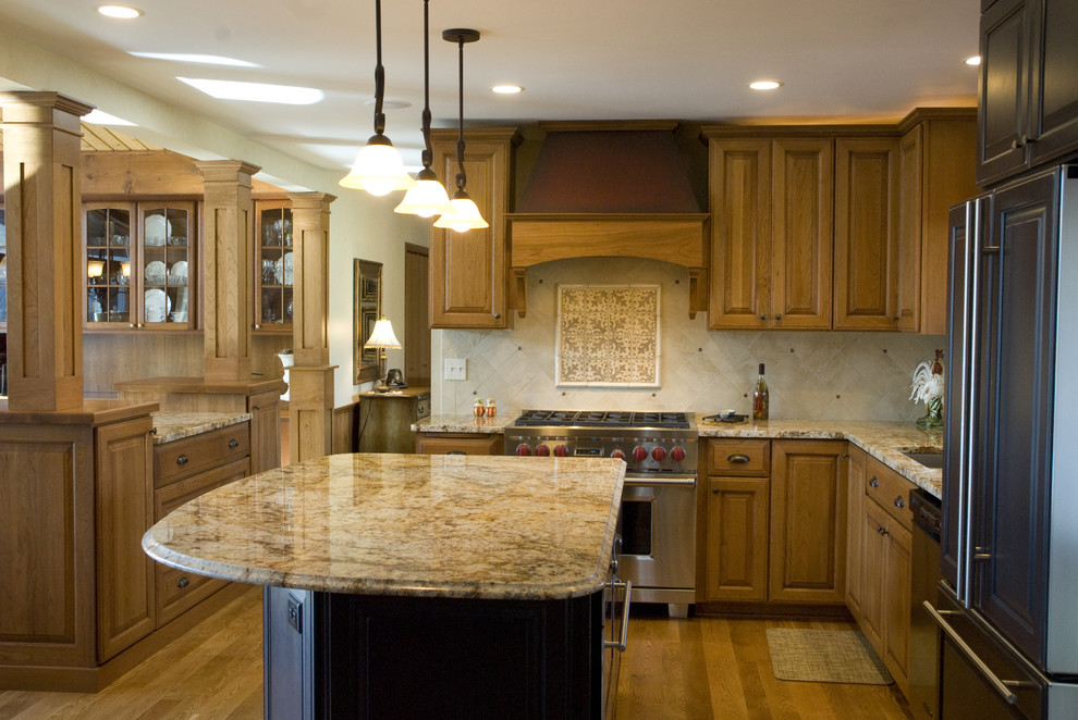 Exempel på ett klassiskt kök, med rostfria vitvaror, granitbänkskiva och stänkskydd i travertin