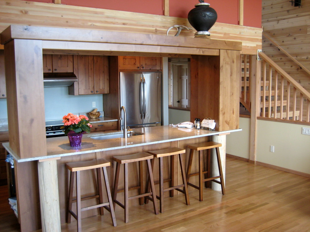 Exempel på ett mellanstort amerikanskt kök, med en undermonterad diskho, skåp i shakerstil, skåp i mellenmörkt trä, granitbänkskiva, rostfria vitvaror och ljust trägolv