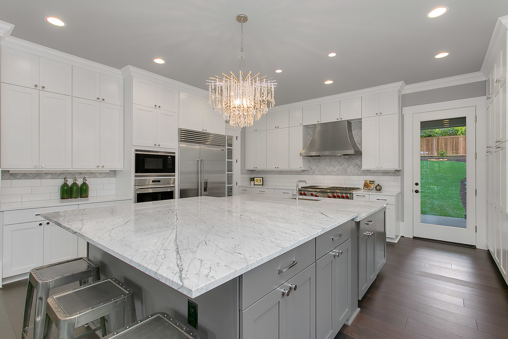 Example of a huge transitional u-shaped dark wood floor eat-in kitchen design in Seattle with a farmhouse sink, flat-panel cabinets, white cabinets, marble countertops, multicolored backsplash, stainless steel appliances and an island