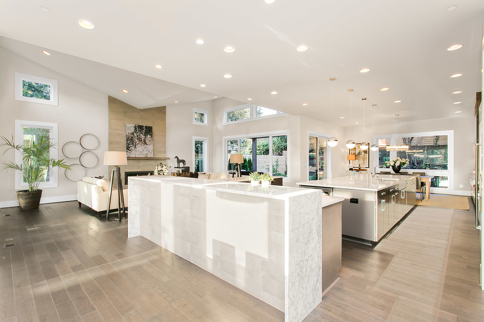 Design ideas for an expansive modern kitchen in Seattle with a built-in sink, flat-panel cabinets, medium wood cabinets, medium hardwood flooring, multiple islands and engineered stone countertops.
