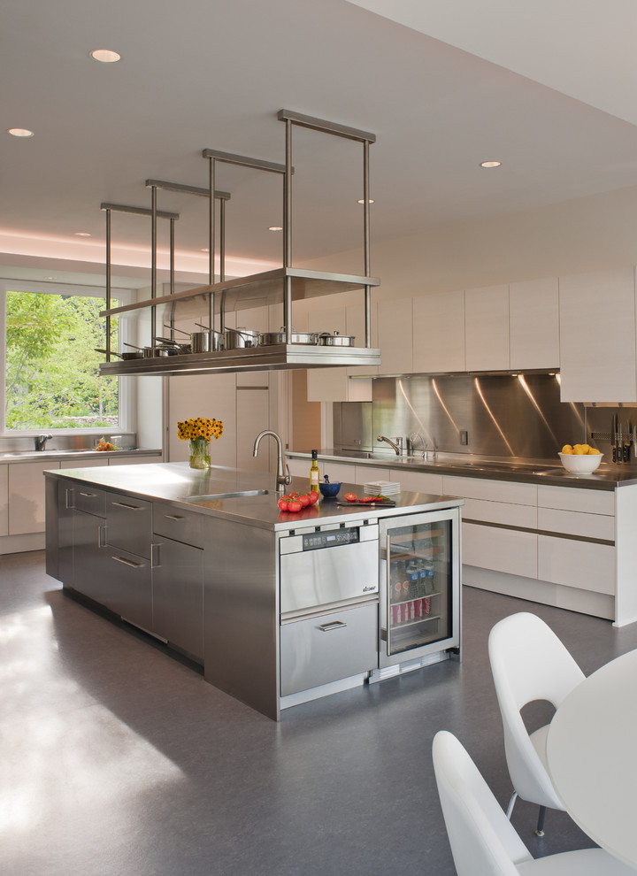 Idéer för ett modernt kök och matrum, med en integrerad diskho, släta luckor, vita skåp, stänkskydd med metallisk yta och rostfria vitvaror