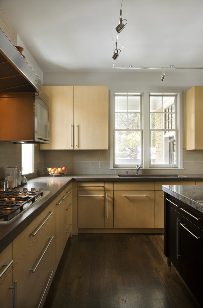 На фото: кухня в современном стиле с плоскими фасадами, светлыми деревянными фасадами и бежевым фартуком