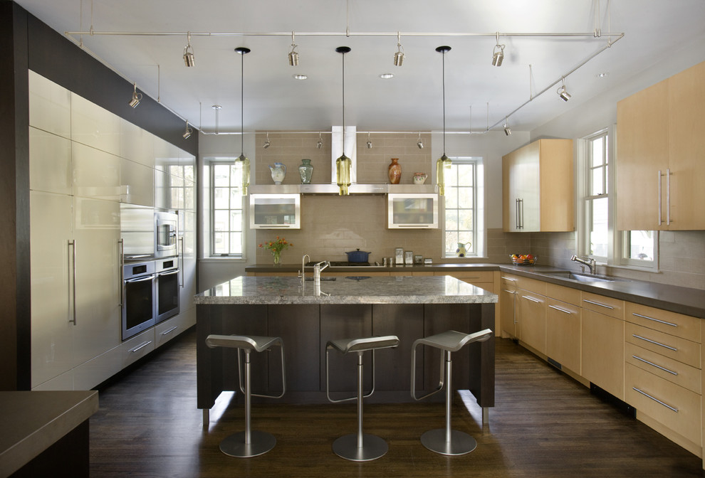 Trendy kitchen photo in Boston with flat-panel cabinets, light wood cabinets, granite countertops, beige backsplash and stainless steel appliances