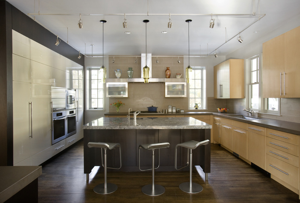 Moderne Küche mit flächenbündigen Schrankfronten, hellen Holzschränken, Granit-Arbeitsplatte, Küchenrückwand in Beige und Küchengeräten aus Edelstahl in Boston