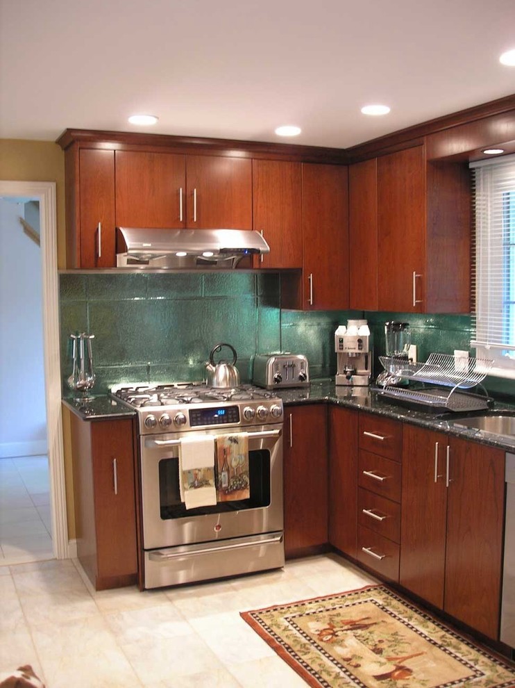 Example of a mid-sized trendy l-shaped ceramic tile and gray floor kitchen design in Boston with an undermount sink, flat-panel cabinets, dark wood cabinets, glass countertops, metallic backsplash, glass tile backsplash and stainless steel appliances