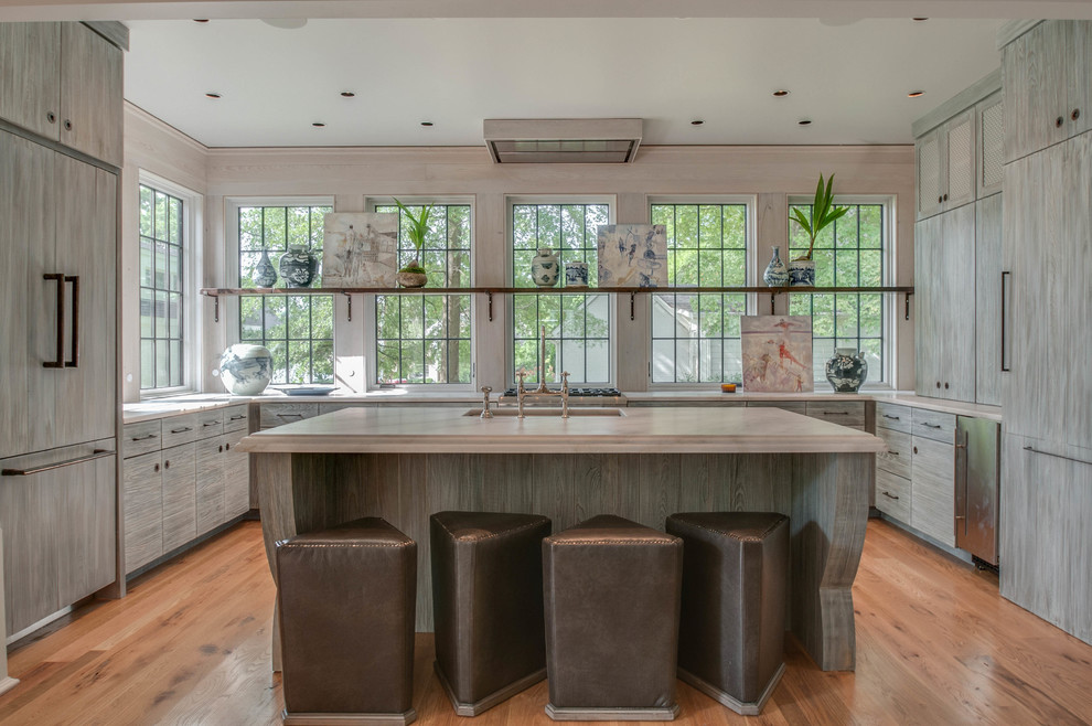 Inspiration for an eclectic u-shaped kitchen in Nashville with a submerged sink, flat-panel cabinets, distressed cabinets, window splashback, integrated appliances, light hardwood flooring, an island and white worktops.