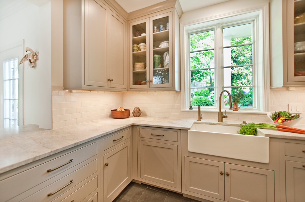 Mid-sized transitional u-shaped porcelain tile open concept kitchen photo in Nashville with a farmhouse sink, recessed-panel cabinets, beige cabinets, quartzite countertops, white backsplash, ceramic backsplash, stainless steel appliances and a peninsula