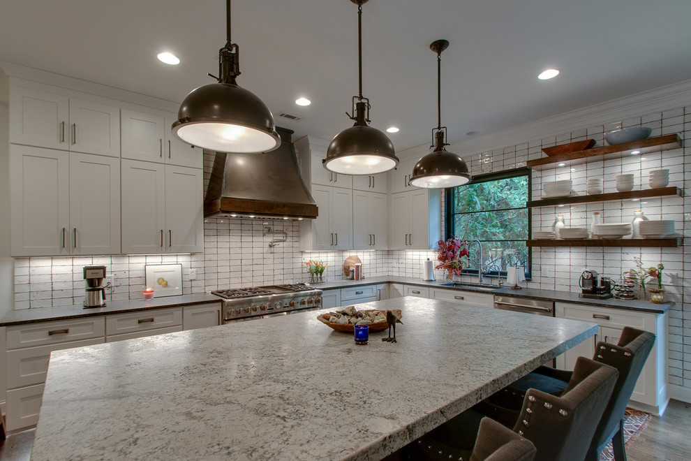 Foto på ett mellanstort shabby chic-inspirerat grå kök med öppen planlösning, med en undermonterad diskho, skåp i shakerstil, vita skåp, granitbänkskiva, vitt stänkskydd, stänkskydd i keramik, rostfria vitvaror, mellanmörkt trägolv, en köksö och brunt golv