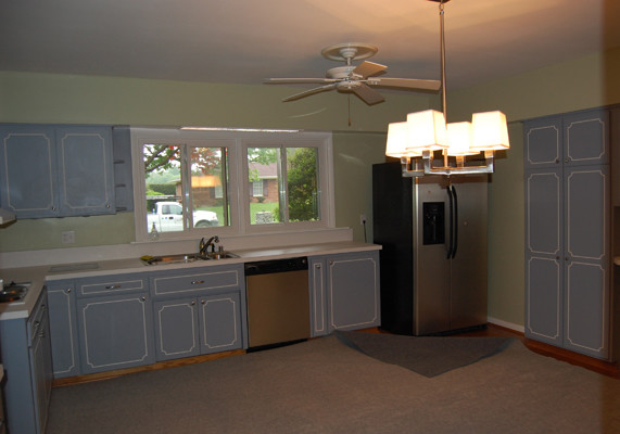 Example of a trendy medium tone wood floor kitchen design in Louisville with a drop-in sink, flat-panel cabinets, light wood cabinets, concrete countertops, multicolored backsplash and stainless steel appliances