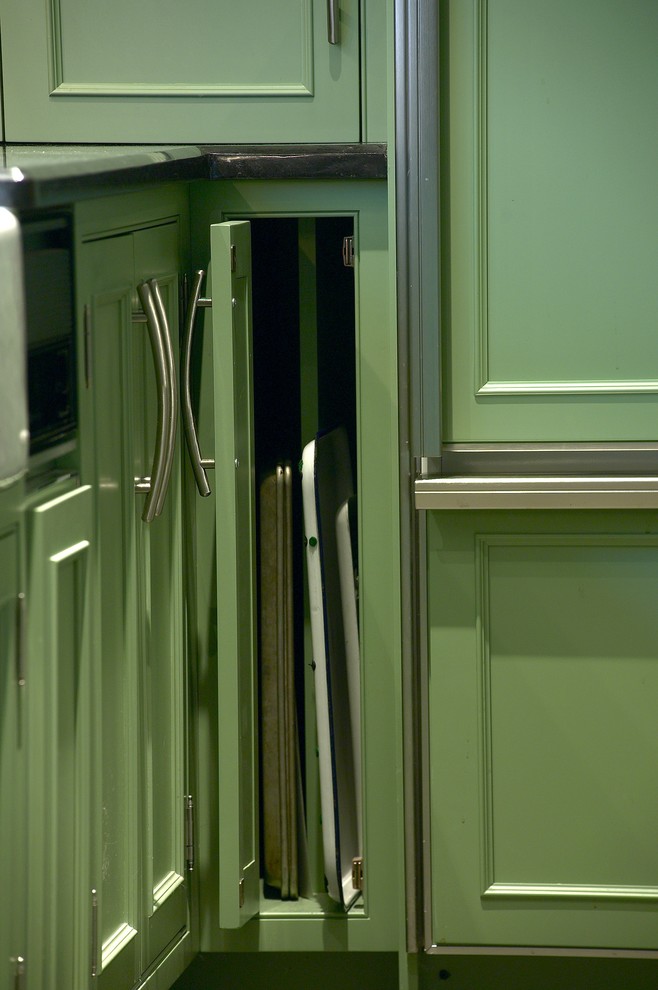 ボストンにある広いエクレクティックスタイルのおしゃれなキッチン (エプロンフロントシンク、落し込みパネル扉のキャビネット、緑のキャビネット、御影石カウンター、黒いキッチンパネル、石スラブのキッチンパネル、黒い調理設備、スレートの床) の写真