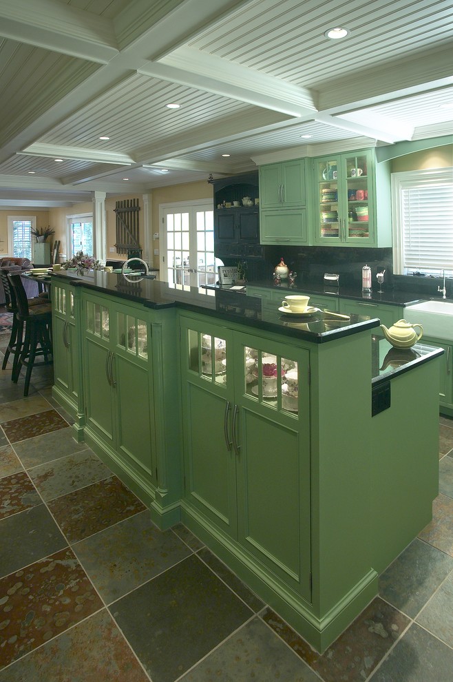 Foto på ett stort eklektiskt kök och matrum, med en rustik diskho, luckor med infälld panel, gröna skåp, granitbänkskiva, svart stänkskydd, stänkskydd i sten, svarta vitvaror, skiffergolv och en köksö