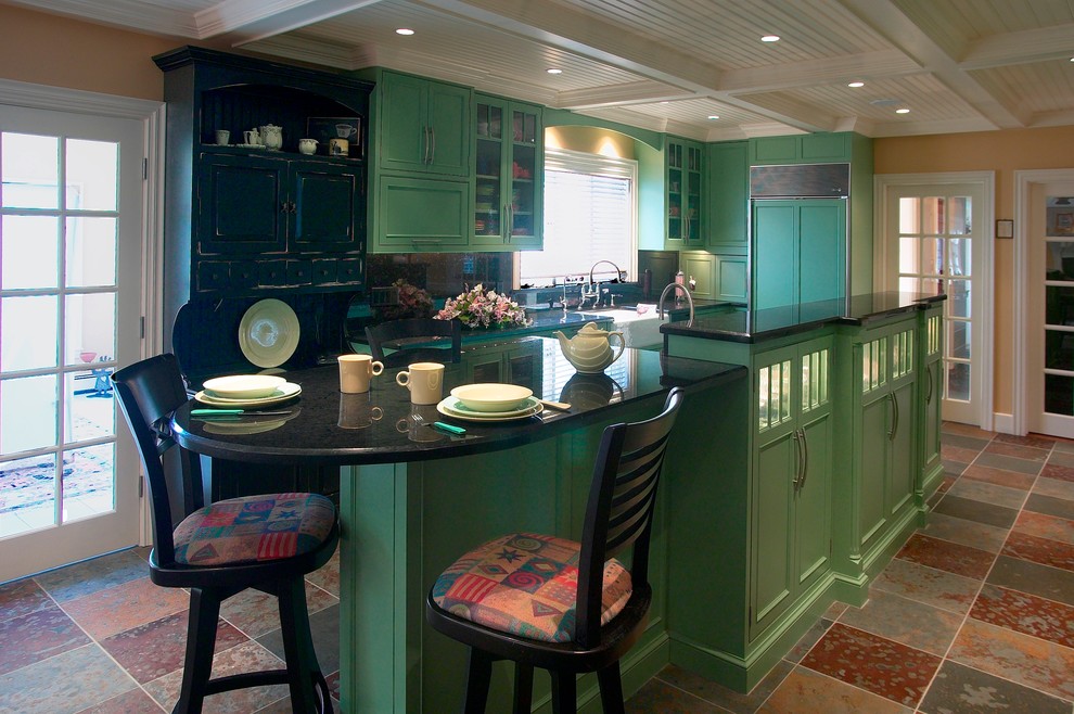 Inspiration for a large eclectic slate floor eat-in kitchen remodel in Boston with a farmhouse sink, recessed-panel cabinets, green cabinets, granite countertops, black backsplash, stone slab backsplash, black appliances and an island