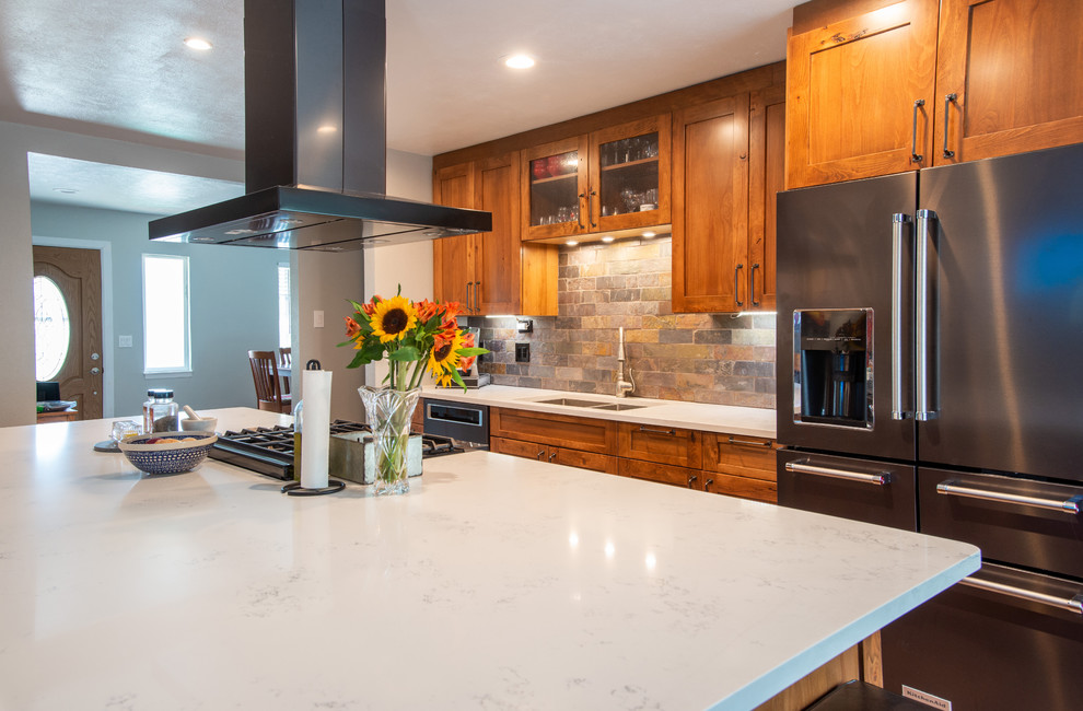 Bild på ett stort rustikt vit vitt kök, med en undermonterad diskho, skåp i shakerstil, bruna skåp, bänkskiva i kvarts, flerfärgad stänkskydd, stänkskydd i skiffer, rostfria vitvaror, mellanmörkt trägolv, en köksö och brunt golv