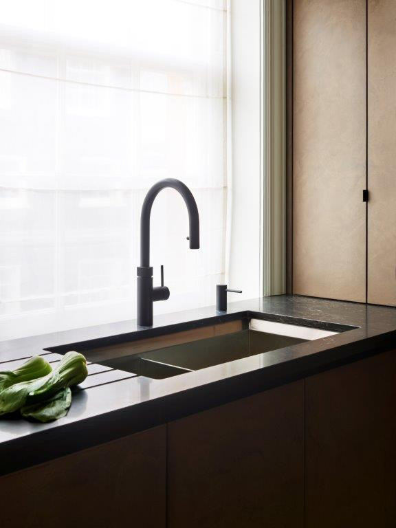 Idéer för ett avskilt, mellanstort modernt l-kök, med en integrerad diskho, släta luckor, granitbänkskiva, stänkskydd med metallisk yta, glaspanel som stänkskydd och svarta vitvaror