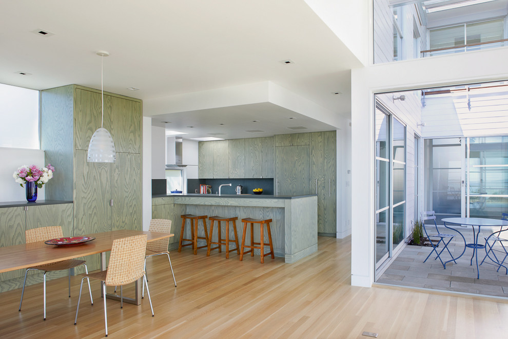 Trendy u-shaped eat-in kitchen photo in San Francisco with flat-panel cabinets, green cabinets and paneled appliances
