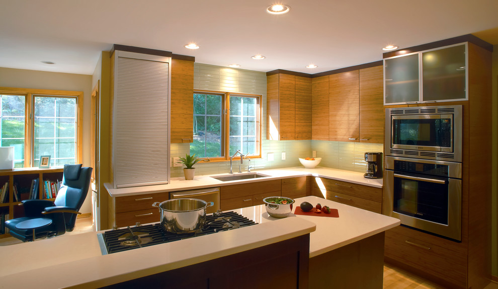 Idéer för ett modernt kök, med en undermonterad diskho, släta luckor, skåp i mellenmörkt trä, stänkskydd i glaskakel och rostfria vitvaror
