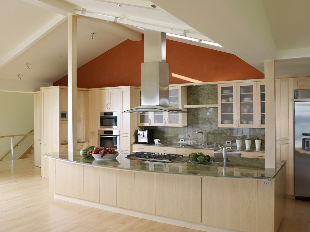 Photo of a contemporary galley open plan kitchen in San Francisco with stainless steel appliances, glass-front cabinets, light wood cabinets, granite worktops, green splashback and stone slab splashback.