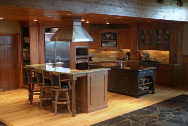 Rustikale Wohnküche mit Landhausspüle, profilierten Schrankfronten, hellen Holzschränken, Granit-Arbeitsplatte, Küchenrückwand in Beige und schwarzen Elektrogeräten in Seattle