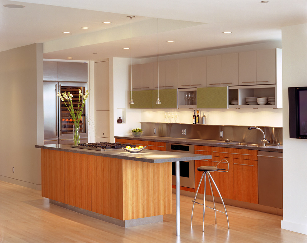 Bild på ett mellanstort funkis linjärt kök med öppen planlösning, med en undermonterad diskho, släta luckor, skåp i mellenmörkt trä, granitbänkskiva, stänkskydd med metallisk yta, rostfria vitvaror, ljust trägolv och en köksö