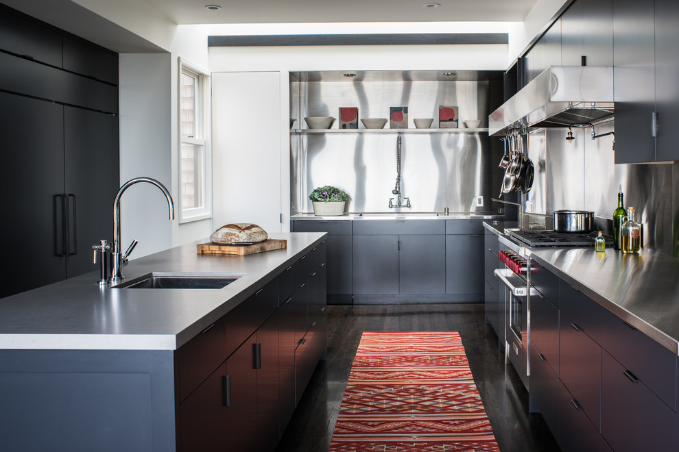 Moderne Küche mit Unterbauwaschbecken, flächenbündigen Schrankfronten, Edelstahl-Arbeitsplatte, Küchenrückwand in Metallic, dunklem Holzboden, Kücheninsel und Küchengeräten aus Edelstahl in San Francisco
