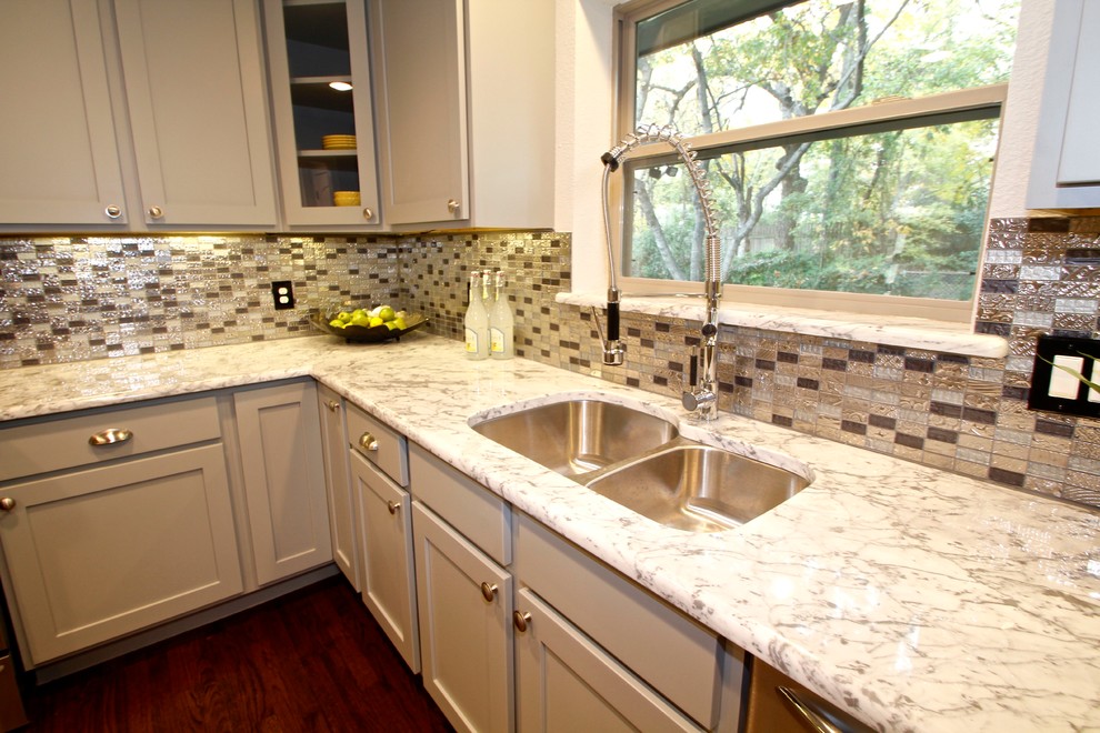 Cette photo montre une cuisine américaine tendance en U avec un évier 2 bacs, un placard à porte shaker, un plan de travail en granite, une crédence multicolore et une crédence en mosaïque.