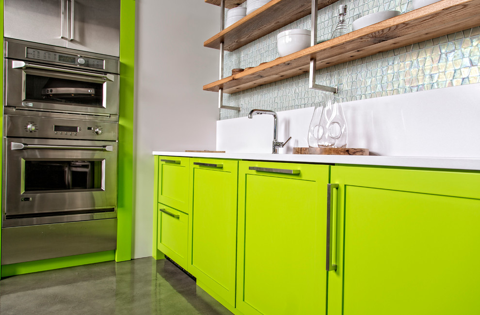 Idéer för ett modernt kök, med skåp i shakerstil, gröna skåp, bänkskiva i kvarts, blått stänkskydd, stänkskydd i keramik, rostfria vitvaror och betonggolv