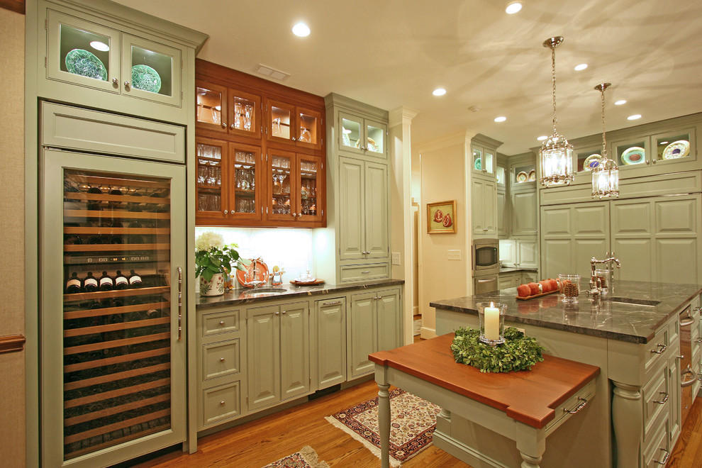 Inspiration for a timeless eat-in kitchen remodel in Charlotte with a farmhouse sink, raised-panel cabinets, green cabinets, soapstone countertops and white backsplash