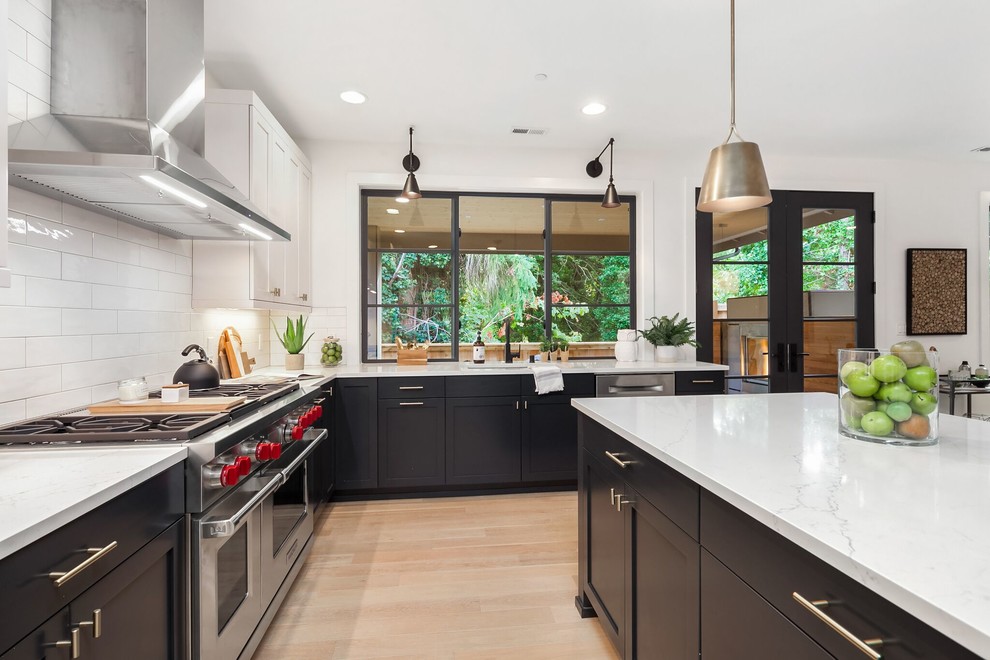 Eat-in kitchen - large transitional l-shaped light wood floor and brown floor eat-in kitchen idea in Seattle with an undermount sink, shaker cabinets, gray cabinets, granite countertops, white backsplash, porcelain backsplash, stainless steel appliances, an island and white countertops