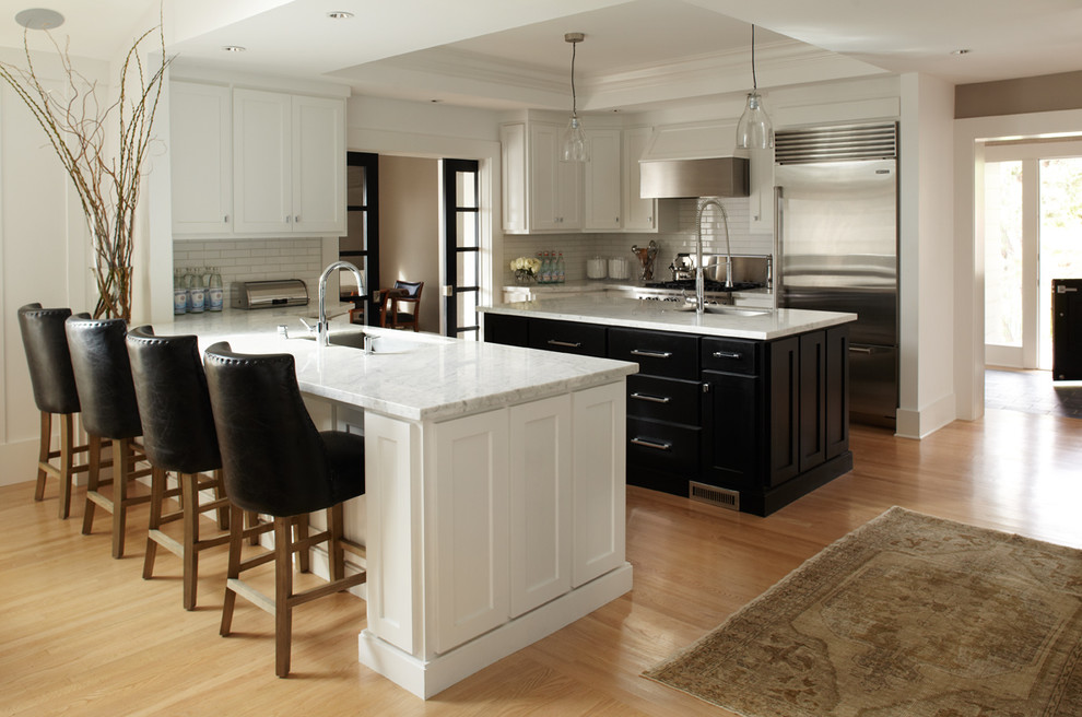 Exempel på ett modernt kök, med stänkskydd i tunnelbanekakel, rostfria vitvaror, en undermonterad diskho, skåp i shakerstil, vita skåp, marmorbänkskiva och vitt stänkskydd