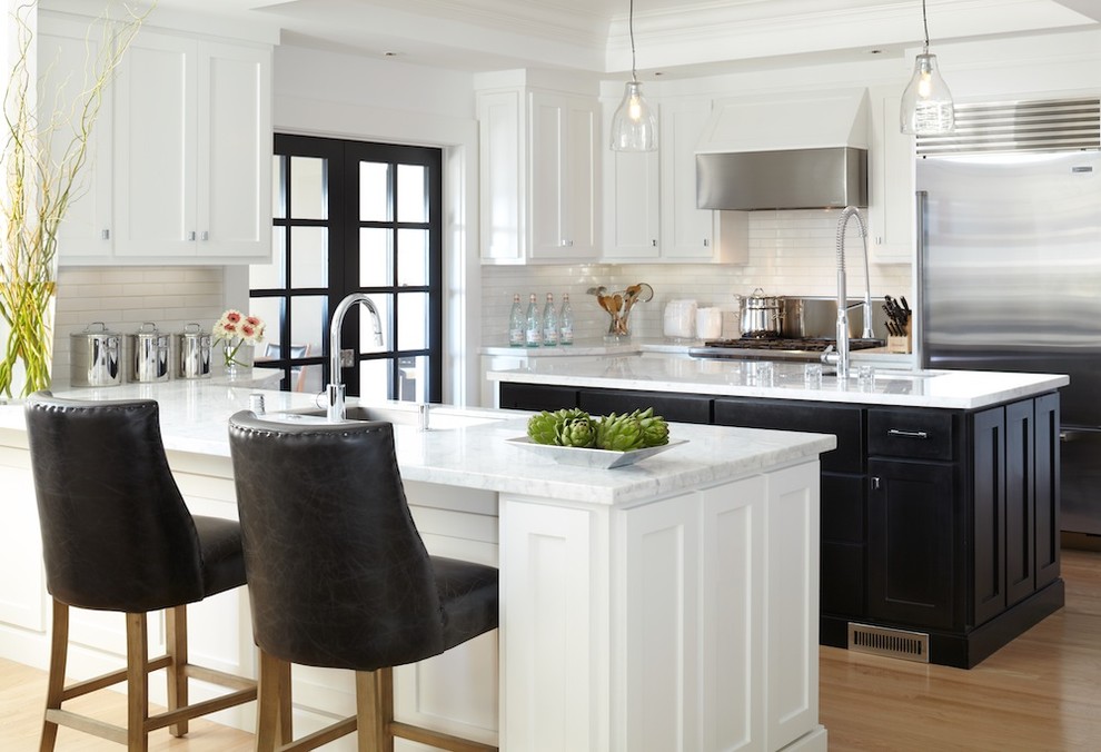 Example of a trendy u-shaped kitchen design in San Francisco with stainless steel appliances, an undermount sink, shaker cabinets, black cabinets, marble countertops, white backsplash and subway tile backsplash