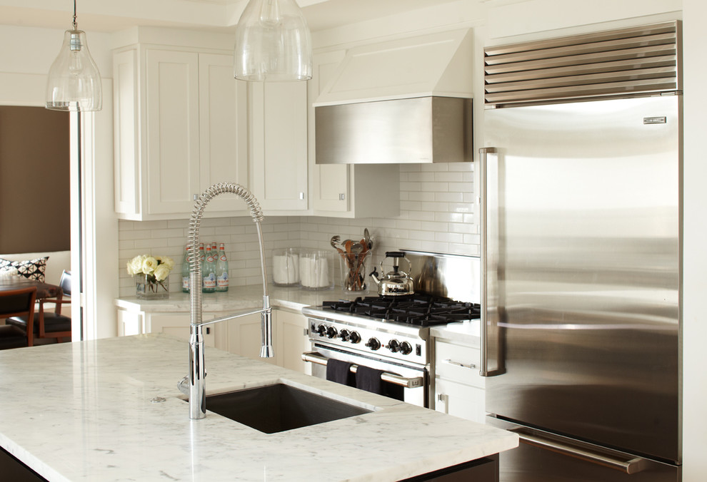 Immagine di una cucina contemporanea con lavello sottopiano, ante in stile shaker, ante bianche, top in marmo, paraspruzzi bianco, paraspruzzi con piastrelle diamantate e elettrodomestici in acciaio inossidabile