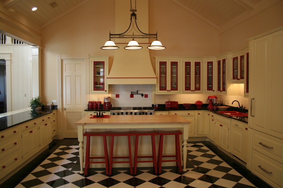 ハンティントンにある広いトラディショナルスタイルのおしゃれなキッチン (ドロップインシンク、ガラス扉のキャビネット、白いキャビネット、御影石カウンター、ベージュキッチンパネル、パネルと同色の調理設備、リノリウムの床) の写真